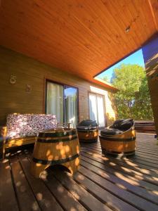 une terrasse couverte avec des canapés et des chaises sur une terrasse en bois dans l'établissement Cabañas SPA Olmue, à Olmué