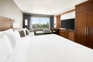 a hotel room with a bed and a flat screen tv at Courtyard by Marriott Los Angeles Woodland Hills in Woodland Hills