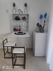 eine Küche mit einem Tisch, einem Tisch und Stühlen in der Unterkunft Hospedagem MAR SANTO in Florianópolis