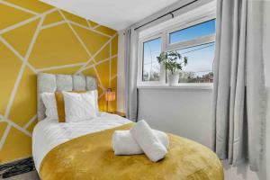 een slaapkamer met een groot bed met een gele muur bij Stylish 3 Bed House Close to NEC in Birmingham