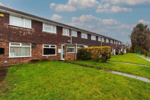 a brick house with a lawn in front of it at Stylish 3 Bed House Close to NEC in Birmingham