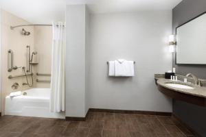 a bathroom with a tub shower and a sink at Courtyard by Marriott Los Angeles Woodland Hills in Woodland Hills