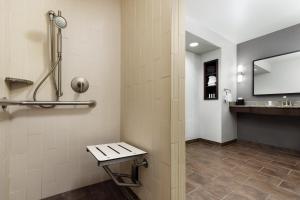 a bathroom with a sink and a bench in it at Courtyard by Marriott Los Angeles Woodland Hills in Woodland Hills