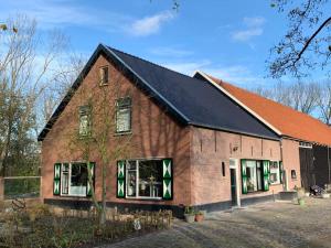 un grand bâtiment en briques avec un toit noir dans l'établissement Boerderij_1898, à Oude-Tonge