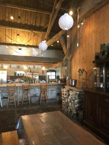 un bar con paredes de madera y taburetes de madera en Boerderij_1898 en Oude-Tonge