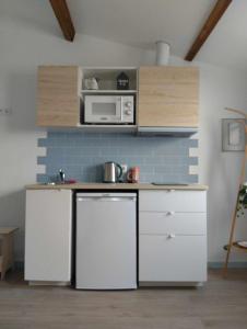 a kitchen with a white refrigerator and a microwave at Maria do Mar_As Três Marias in Matosinhos