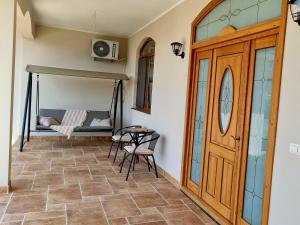 a room with a porch with a swing and a table at Denisa in Limanu