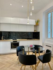 a kitchen with a glass table and black chairs at Grands T2 Cours Napoleon in Ajaccio