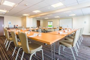 une grande salle de conférence avec une grande table et des chaises dans l'établissement Holiday Inn Newcastle Gosforth Park, an IHG Hotel, à Newcastle upon Tyne