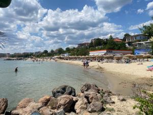 a beach with people in the water and rocks at TONI HOUSE 407 Apartment Sveti Vlas Beach in Sveti Vlas