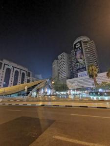Cloud9 Premium Hostel في دبي: أفق المدينة في الليل مع المباني الطويلة