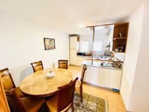 a kitchen and dining room with a wooden table and chairs at Gërmia House - Prishtinë in Sofalija