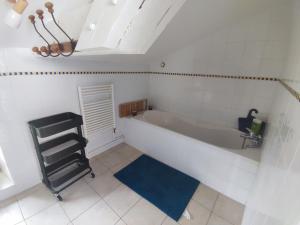 La salle de bains est pourvue d'une baignoire et d'un tapis bleu. dans l'établissement Maison de campagne vue panoramique, à Rozier-en-Donzy