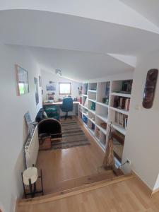 un salon avec un escalier menant à une chambre avec des étagères dans l'établissement Maison de campagne vue panoramique, à Rozier-en-Donzy