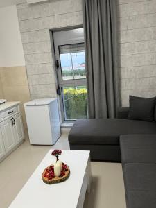 een woonkamer met een bank, een tafel en een raam bij Apartments MASIMO in Donji Štoj
