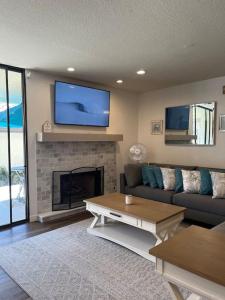 a living room with a couch and a tv above a fireplace at Paradise resort living Mandalay beach in Oxnard