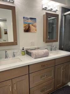 a bathroom with two sinks and two mirrors at Paradise resort living Mandalay beach in Oxnard