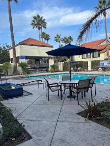 a table with chairs and an umbrella next to a pool at Paradise resort living Mandalay beach in Oxnard