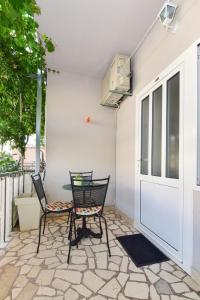 2 Stühle und ein Tisch auf der Terrasse in der Unterkunft Apartments Bernarda in Makarska