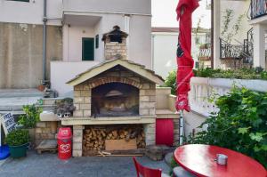einen Pizzaofen im Freien mit einem Tisch und Stühlen in der Unterkunft Apartments Bernarda in Makarska