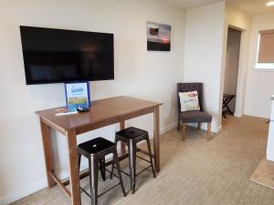 a room with a desk with stools and a flat screen tv at Moonstone Beach Motel in Moclips