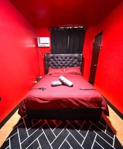um quarto vermelho com uma cama com uma parede vermelha em The RedRoom 1Bedroom Staycation em Anabu Primero