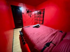 um quarto vermelho com uma cama com uma cabeceira preta em The RedRoom 1Bedroom Staycation em Anabu Primero