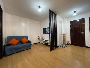 uma sala de estar com um sofá azul e um espelho em The RedRoom 1Bedroom Staycation em Anabu Primero
