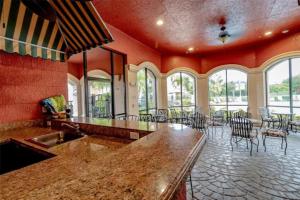a kitchen with a counter and chairs and windows at Bayview in Clearwater