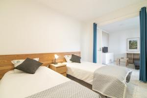 a hotel room with two beds and a desk at Livramento Residence in Livramento