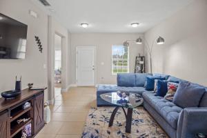 ein Wohnzimmer mit einem blauen Sofa und einem Tisch in der Unterkunft Luxury and tranquility, In the Heart of Poinciana, just 30 min from Disney! in Poinciana