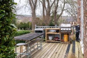 a wooden deck with a picnic table and a grill at Quiet 2 bedroom home with cozy fire. in Ebchester