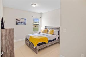 ein Schlafzimmer mit einem Bett mit einer gelben Decke darauf in der Unterkunft Luxury and tranquility, In the Heart of Poinciana, just 30 min from Disney! in Poinciana