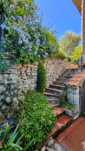 a stone wall with stairs and flowers on it at Il Piccolo Mulino in Portovenere