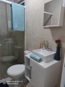 a bathroom with a white sink and a toilet at Hospedagem MAR SANTO in Florianópolis