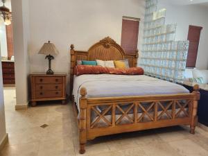 een slaapkamer met een houten bed en een nachtkastje bij Beachfront Condo directly on the private beach - Ground Floor in Six Huts