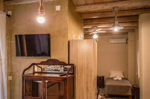 a room with a tv and a table and a bed at Mitato Eagle's Nest Trouloto in Níthavris