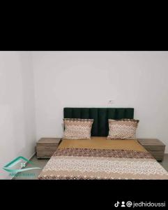 a large bed with a green headboard in a room at Family corner in Ḩammām al Ghazzāz