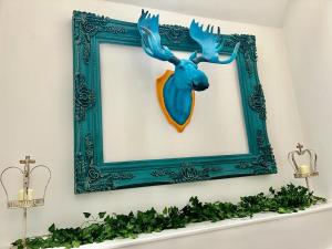 una cornice blu con una testa di renna su uno scaffale di 5 Bedroom House -Sleeps 12- Big Savings On Long Stays! a Braintree