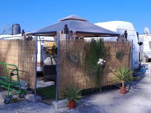 a privacy fence with a tent and some plants at Caravana Villa Rosa in Málaga