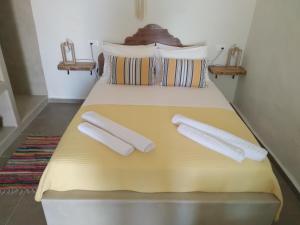 een geel bed met twee witte kussens erop bij ALEMINAS HOUSE in Symi