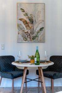 a table with two wine glasses and a painting on the wall at Businessapartment Zentral & Modern nahe Hauptbahnhof, schnelles WLAN in Essen