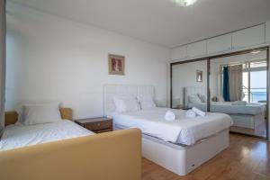 a bedroom with two beds and a mirror at Iconic Penthouse Apartment 706 on Beach in Funchal