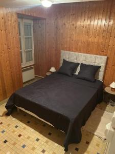 - une chambre avec un grand lit et des murs en bois dans l'établissement Gîte Le Hamo, à Saint-Fort