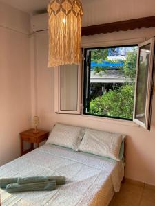 een slaapkamer met een bed en een groot raam bij The view in Poros