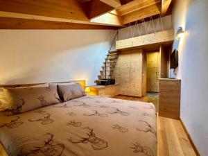 a bedroom with a large bed and a staircase at Alpine Escape in Bormio