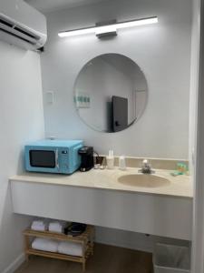a bathroom with a sink and a microwave on a counter at Single King Room in Lake City