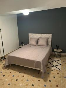 een slaapkamer met een groot bed met een blauwe muur bij Gîte Le Hamo in Saint-Fort