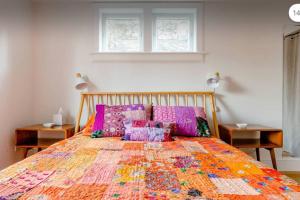 una cama con una colcha colorida en un dormitorio en VACATION Mod Cottage Idyllic Setting Every Amenity, en Rosendale