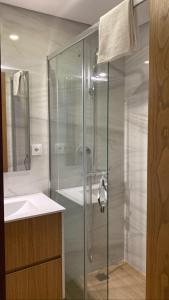uma cabina de duche em vidro na casa de banho com um lavatório em CASA DAS QUINTÃES 